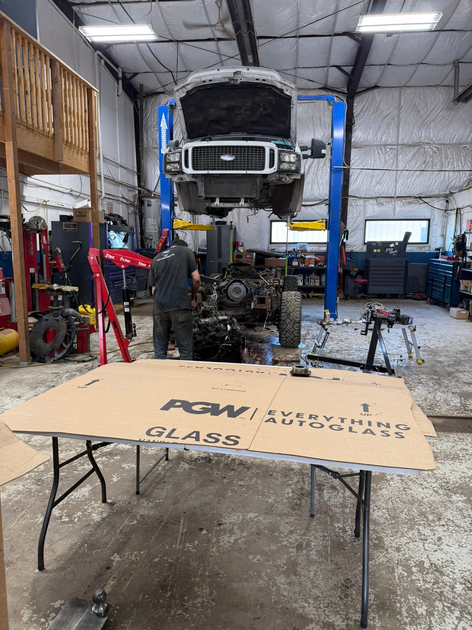 Technician working below a lifted truck